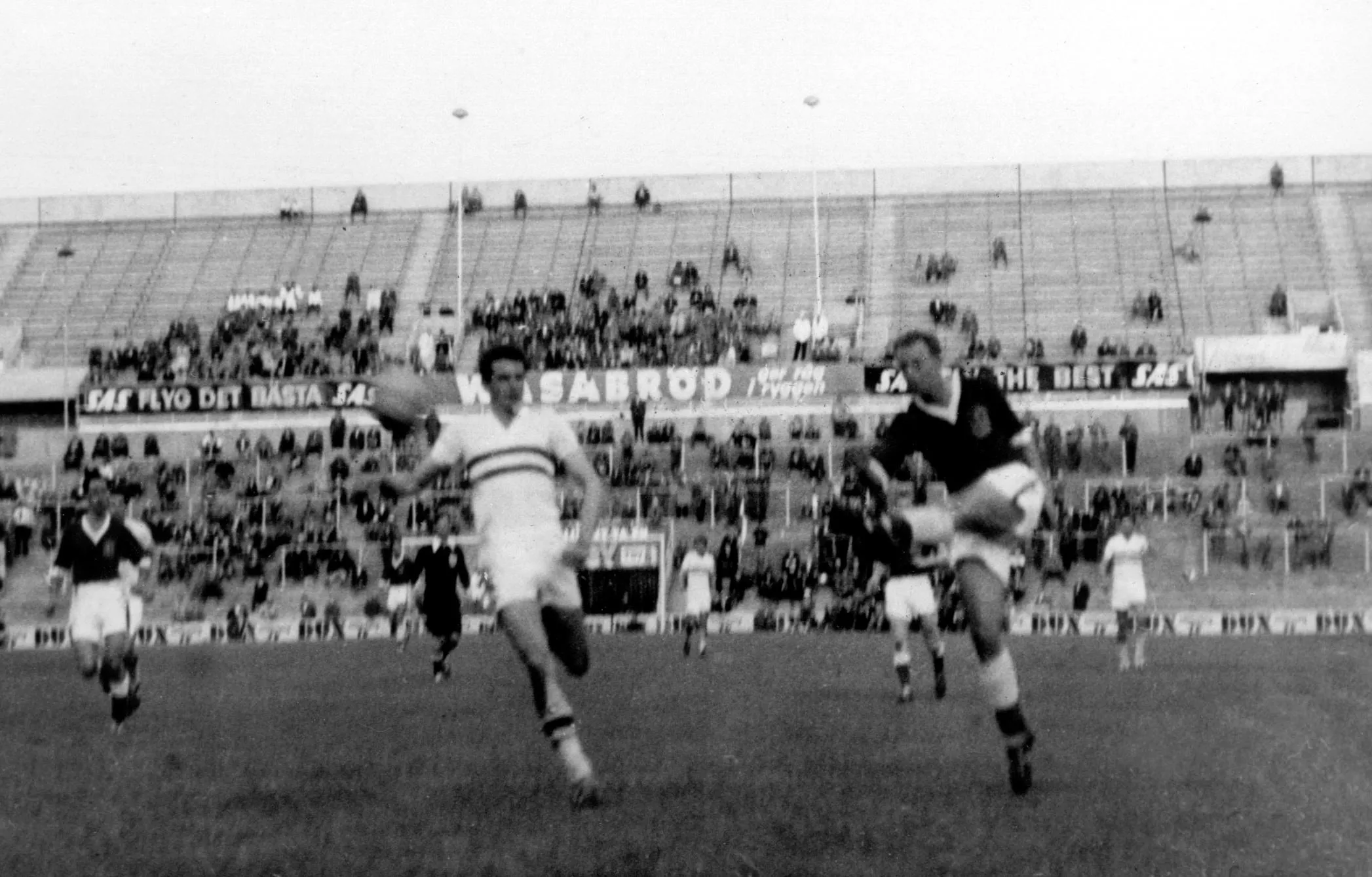 Welsh striker Ivor Allchurch, with a defender to his left, scores the opening goal against Hungary at the 1958 World Cup in Sweden.