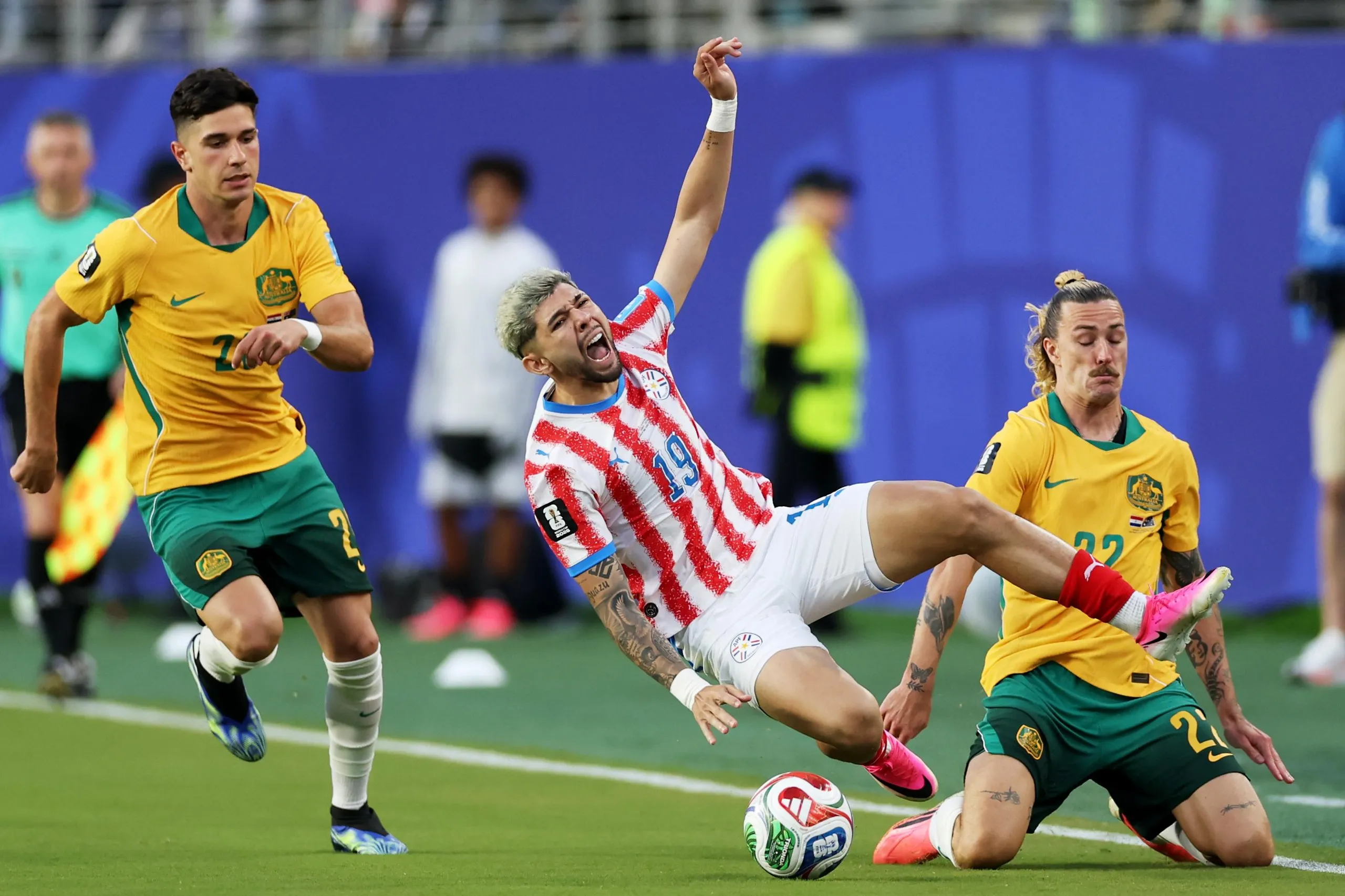 Julio Enciso of Paraguay is tackled by Jackson Irvine