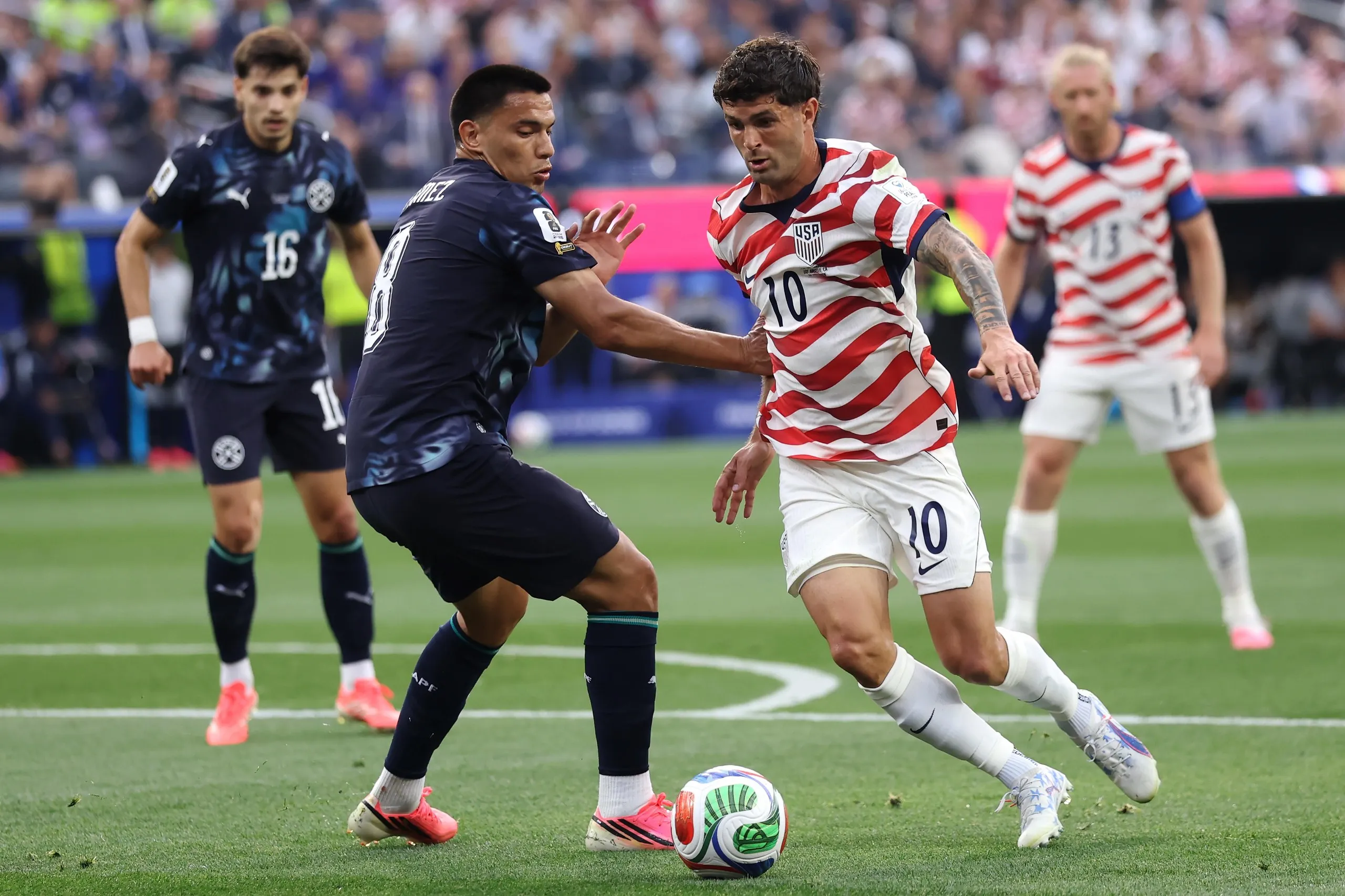 Christian Pulisic of USA battles for the ball with Diego Gomez of Paraguay during the FIFA World Cup 2026 Group D match between USA and Paraguay at Los Angeles Stadium on June 12, 2026 in Los Angeles, California.