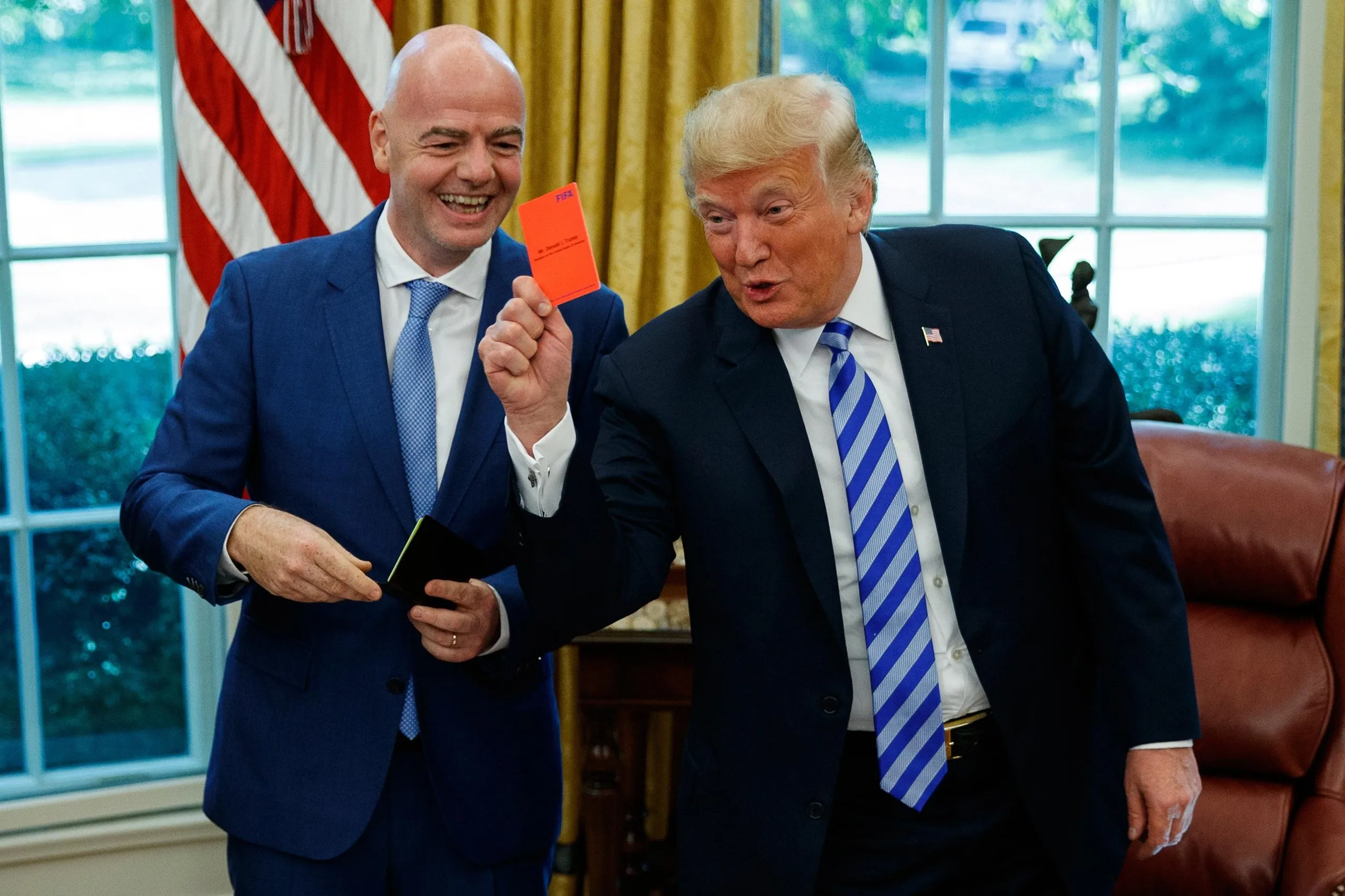 The American president, Donald Trump, holds up a red card during a meeting with the Fifa president, Gianni Infantino, in 2018.