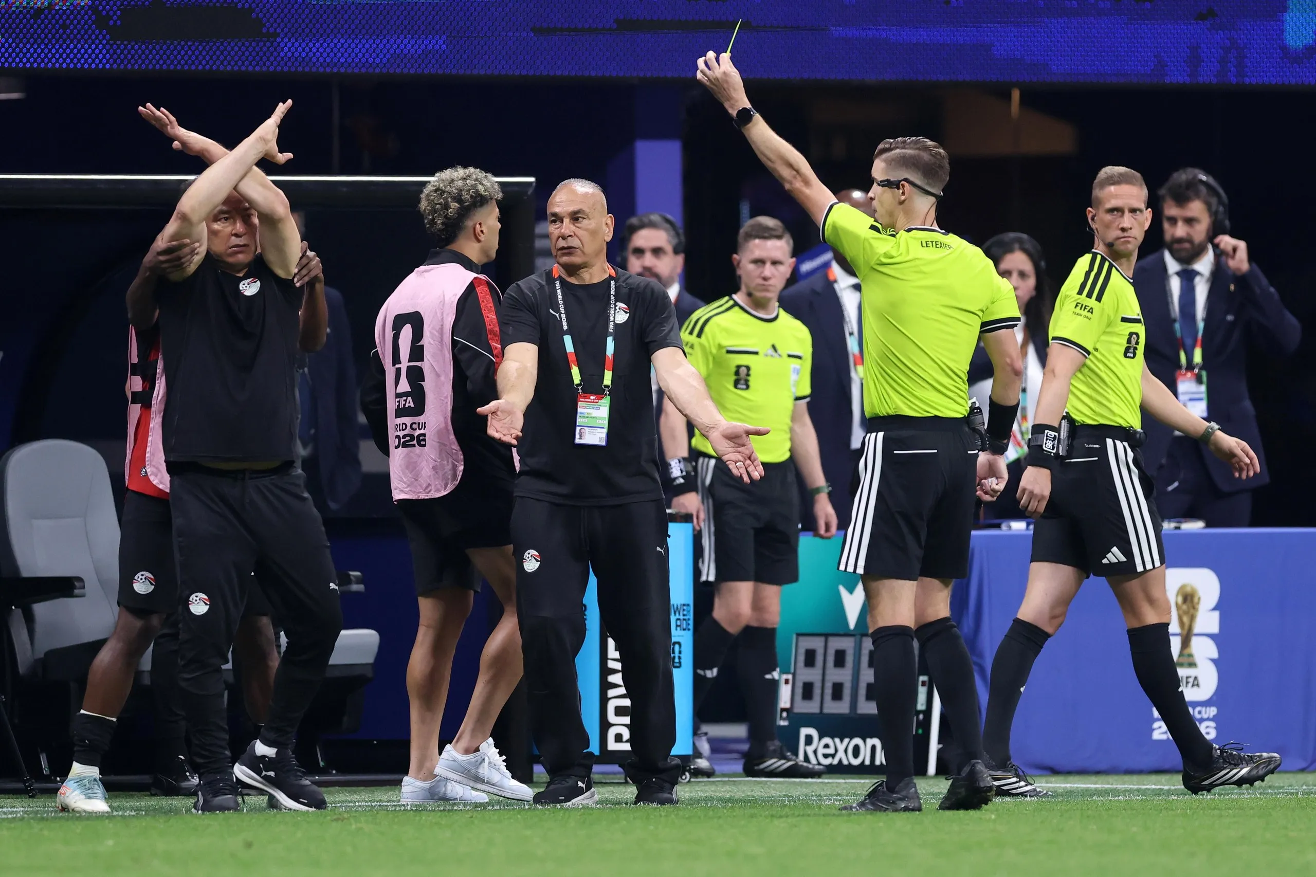 Hossam Hassan crosses his arms in protest as he is booked by François Letexier